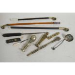 A collection of curios including three opium pipes, a matte spoon, two heavy brass seals, button