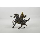 A Chinese bronzed metal figure of a warrior on horseback with gilt polished highlights, 7½" long