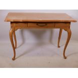 A French style oak single drawer side/writing table, with shaped top, raised on cabriole supports,