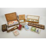 A box of traditional wooden cribbage boards and packs of playing cards, together with a box of