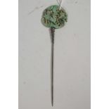 A Chinese white metal hairpin with a green jade knop with carved and pierced deer and bird