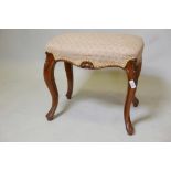 A Victorian walnut stool, raised on cabriole supports and carved decoration, 19" x 13" x 18"