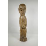 An African carved wood ethnic figure of a squatting man, 28" high