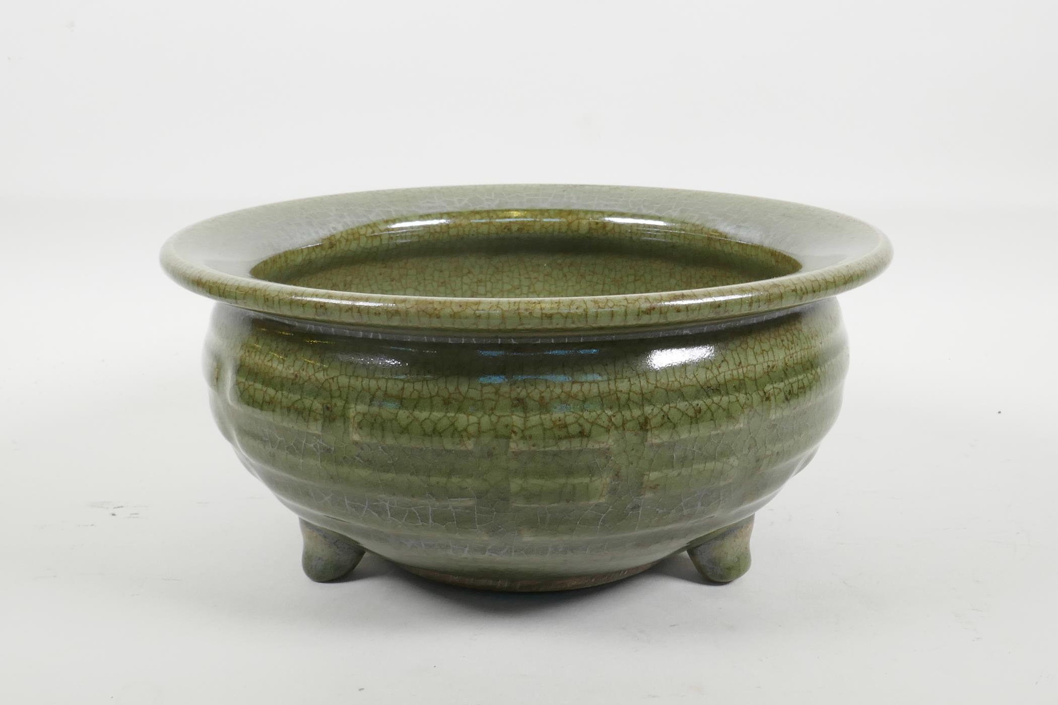 A Chinese olive green crackle glazed pottery bowl with tripod support, 9" diameter