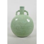 A Chinese celadon glazed porcelain moon flask with two handles, with underglaze dragon decoration,