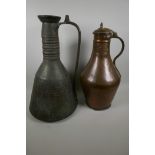 A Middle Eastern copper ewer with hinged cover, 19" high, together with a conical ewer with ribbed
