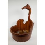 An ethnic wooden washbowl, the handle carved as the neck and head of a crane, 16" diameter, 24" high
