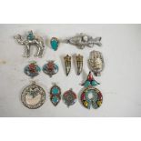 An assorted collection of twelve Indian stone set white metal pendants and rings, many in the form