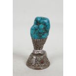 A Tibetan white metal and turquoise seal chased and engraved with mythical beasts, 4½" high