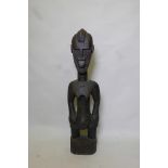 An African carved wood ethnic fertility figure of a woman, 39" high