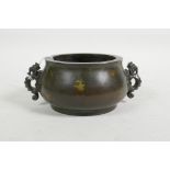 A Chinese bronze censer with two dragon shaped handles and gilt splash decoration, impressed mark to