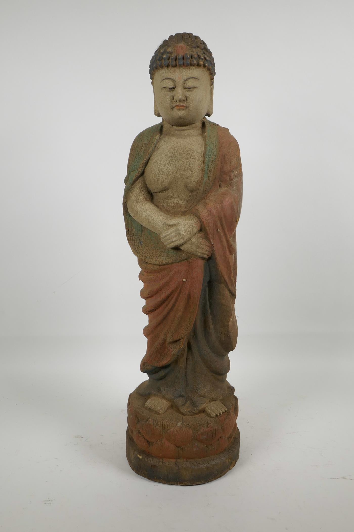 A Chinese carved wood Buddha with cracked polychrome paintwork, 22" high