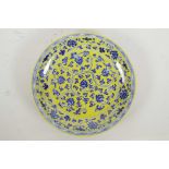 A Chinese yellow ground porcelain dish with blue and white scrolling lotus flower decoration, 6