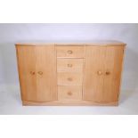 A 1940s/50s oak sideboard, with shaped front and two cupboards flanking a flight of four drawers,