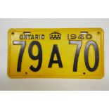 A replica Canadian Ontario 1940 vehicle license plate, embossed metal sprayed yellow with black