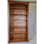 A pine open bookcase with two fixed and three adjustable shelves, raised on bun feet, 37" x 12" x