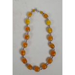 An amber style beaded necklace with white metal mounts, 22" long