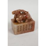 A Chinese carved soapstone seal carved as a deer on a plinth, the plinth engraved with
