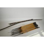 A wooden bow and twenty three bamboo hunting arrows from Papua New Guinea, possibly 1950s,