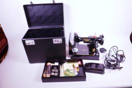 A Singer portable electric sewing machine No.221K1 with carry case and sewing accessories,
