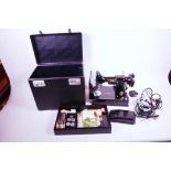 A Singer portable electric sewing machine No.221K1 with carry case and sewing accessories,