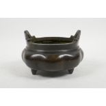 A Chinese bronze two handled censer of lobed form, raised on tripod feet, impressed 6 character mark