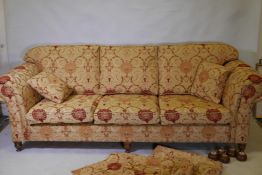 A good quality Ashley Lawrence three seat sofa with terracotta and gold upholstery, raised on turned