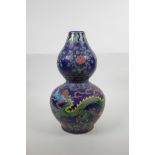 A Chinese blue ground porcelain double gourd vase with raised polychrome dragon, flaming pearl and