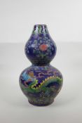 A Chinese blue ground porcelain double gourd vase with raised polychrome dragon, flaming pearl and