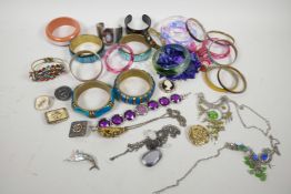 A tin of costume jewellery including a gilt metal pendant set with agate and seed pearls, and an