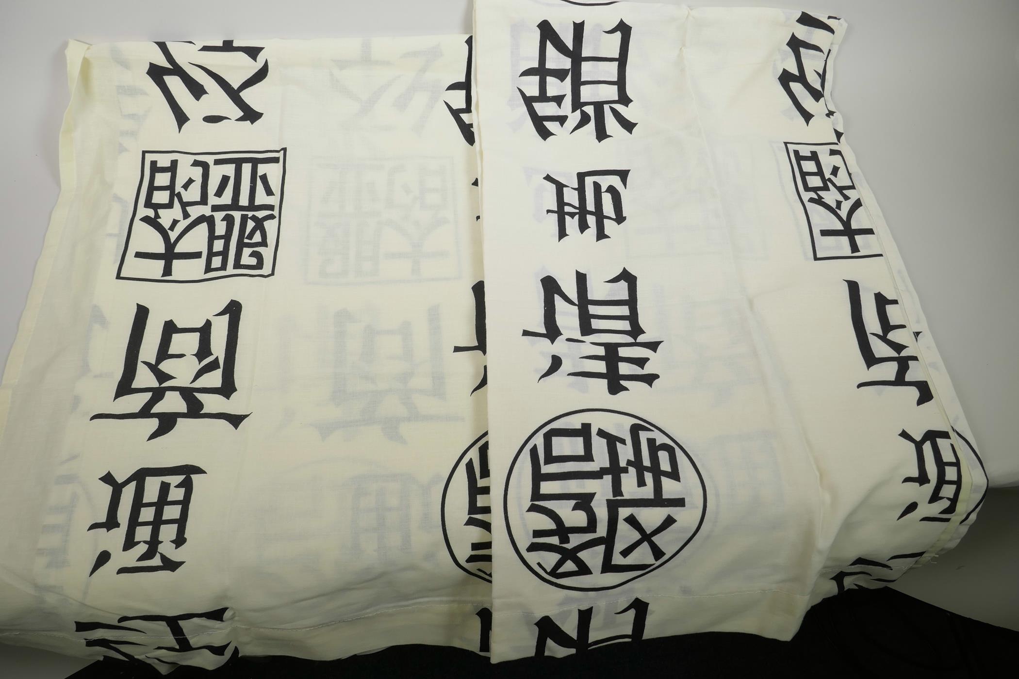 A pair of linen curtains printed with Chinese characters in black on cream, 62" wide, 53" drop