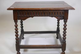 A C17th/18th oak centre table with all round carved frieze, raised on turned supports, united by