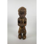 An unusual African carved wood tribal figure, with applied coarse hair decoration, 20½" high