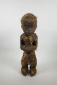 An unusual African carved wood tribal figure, with applied coarse hair decoration, 20½" high