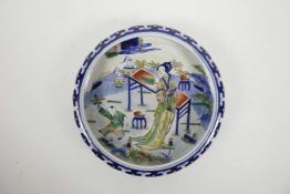 A Chinese blue and white porcelain shallow dish with a rolled rim and doucai enamel decoration of
