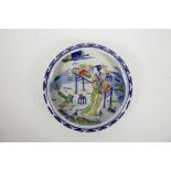 A Chinese blue and white porcelain shallow dish with a rolled rim and doucai enamel decoration of