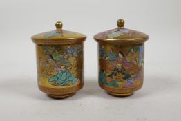 A pair of Japanese Satsuma cylinder pots and covers, decorated with figures, seal mark to base, 4"