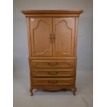 A one piece oak press cupboard, the cupboard fitted with slide for TV, over three long drawers,