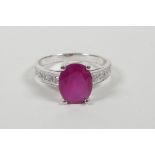 A 925 silver and ruby ring with cubic zirconium set shoulders, approximate size 'R'