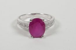 A 925 silver and ruby ring with cubic zirconium set shoulders, approximate size 'R'