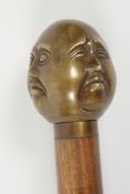 A hardwood walking stick with brass four face Buddha handle, 36" long