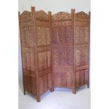 An Indian teak four fold table screen, with carved and pierced panels and grape and vine decoration,