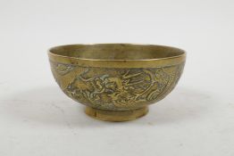 A Chinese bronze bowl with raised and chased dragon and phoenix decoration, six character mark to