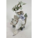 A Lladro porcelain figure of a girl seated on a bench under a tree, model No. 5365, 9" high