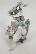 A Lladro porcelain figure of a girl seated on a bench under a tree, model No. 5365, 9" high