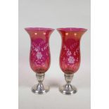 A pair of sterling silver and cranberry glass hurricane candlesticks with slice cut floral