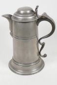 A large pewter lidded jug with scroll handle, 11" high