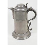 A large pewter lidded jug with scroll handle, 11" high