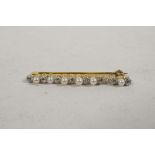 An early C20th yellow metal bar brooch with seed pearls and diamonds in white metal, (one pearl
