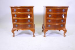A pair of commode style wood bedside chests, with four drawers each, brass handles and carved